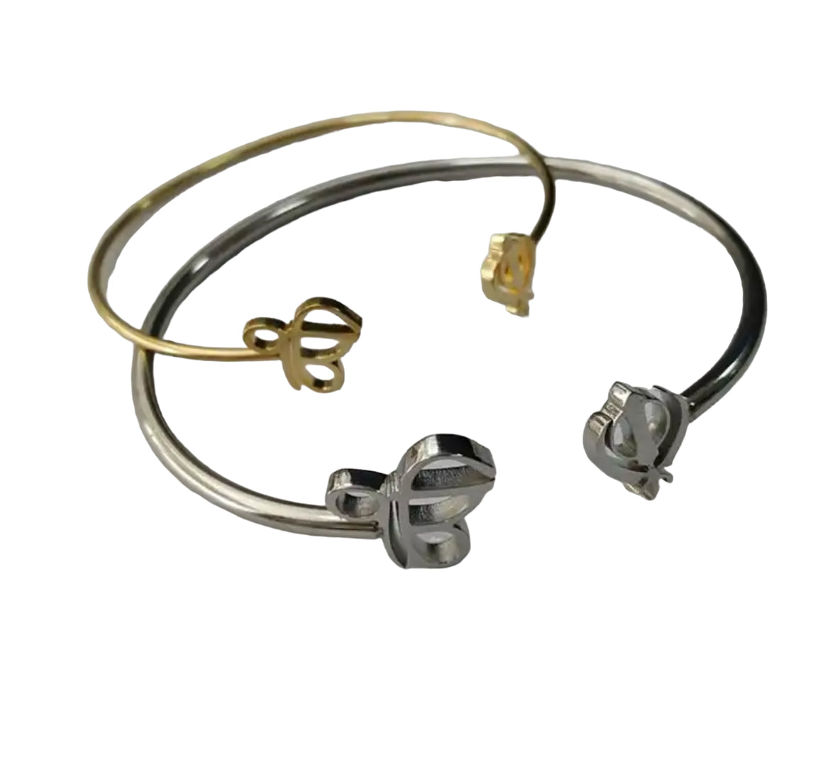The Sikh Khanda Bangle Bracelets are a stunning representation of cultural pride and elegant fashion. Featuring the revered Ek Onkar and Khanda symbols, these bracelets are available in both gold and silver finishes, catering to different style preferences. They offer a unique blend of traditional symbolism and modern design, making them suitable for both everyday wear and special occasions. The design of the Sikh Khanda Bangle Bracelets is both sophisticated and meaningful.
