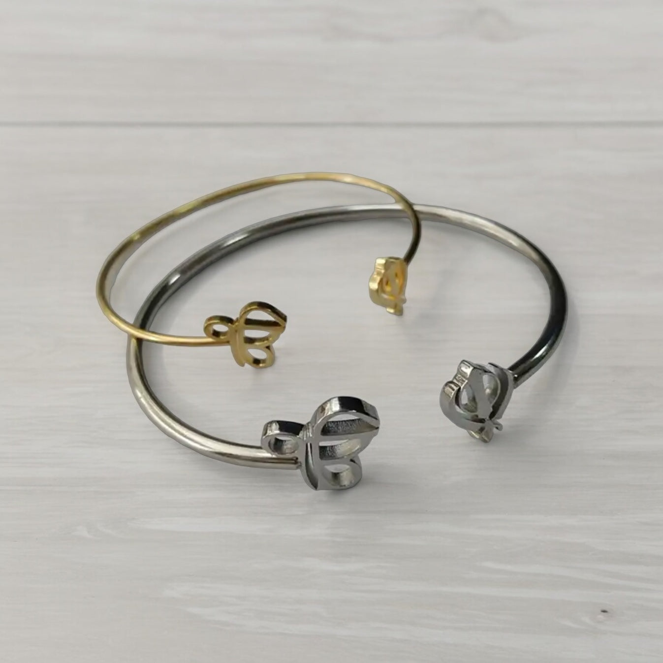 The Sikh Khanda Bangle Bracelets are a stunning representation of cultural pride and elegant fashion. Featuring the revered Ek Onkar and Khanda symbols, these bracelets are available in both gold and silver finishes, catering to different style preferences. They offer a unique blend of traditional symbolism and modern design, making them suitable for both everyday wear and special occasions. The design of the Sikh Khanda Bangle Bracelets is both sophisticated and meaningful.